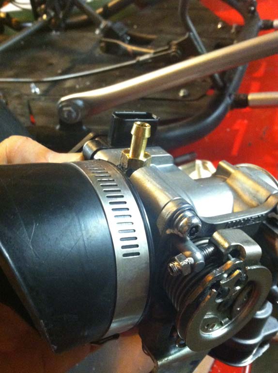 Image of throttle body with brass fitting installed.